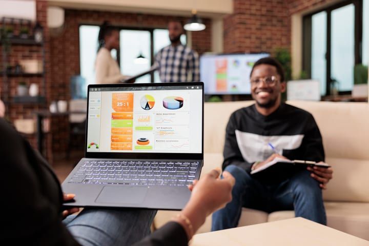 Recruiter smiling during a talent review with charts on a laptop