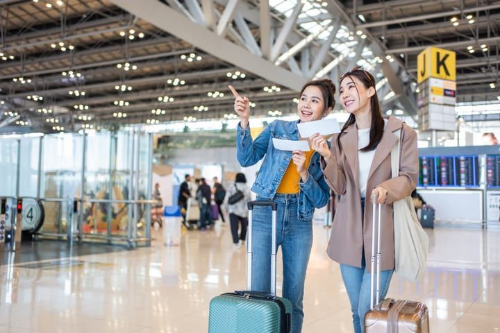 Travellers with luggage walking through an airport